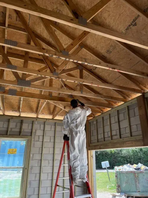 mold technician spraying mold prevention polymer on rafters for new home in Ponte Vedra, FL